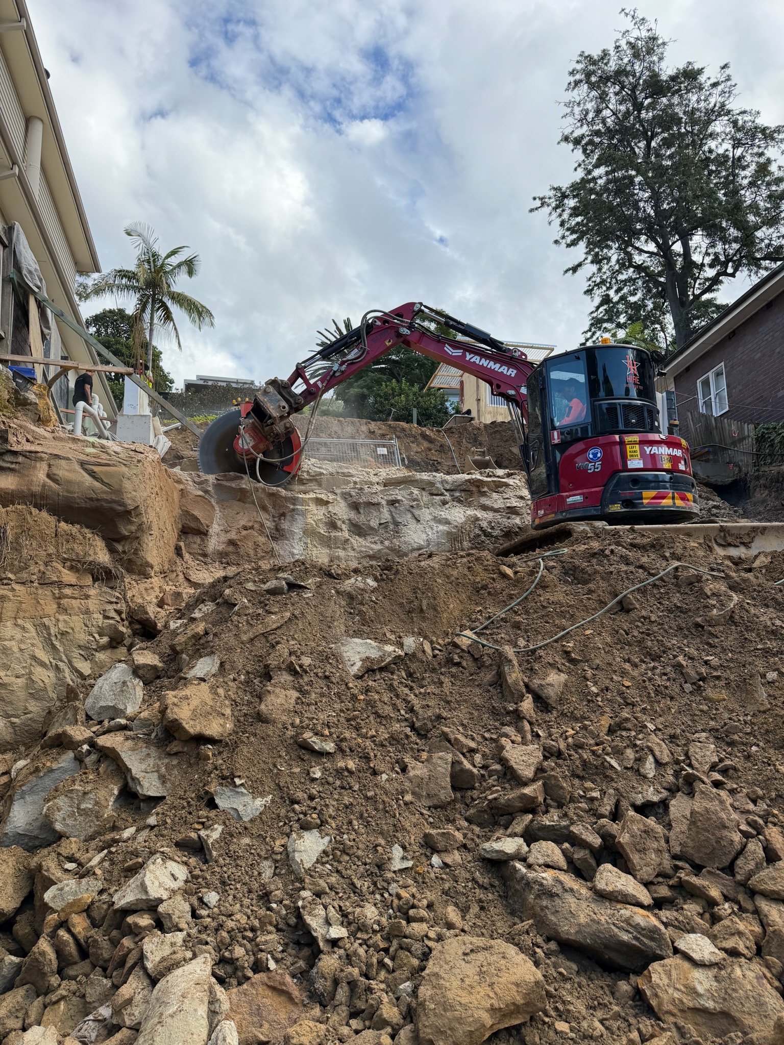 Excavator saw cutting through rock during rock excavation works.